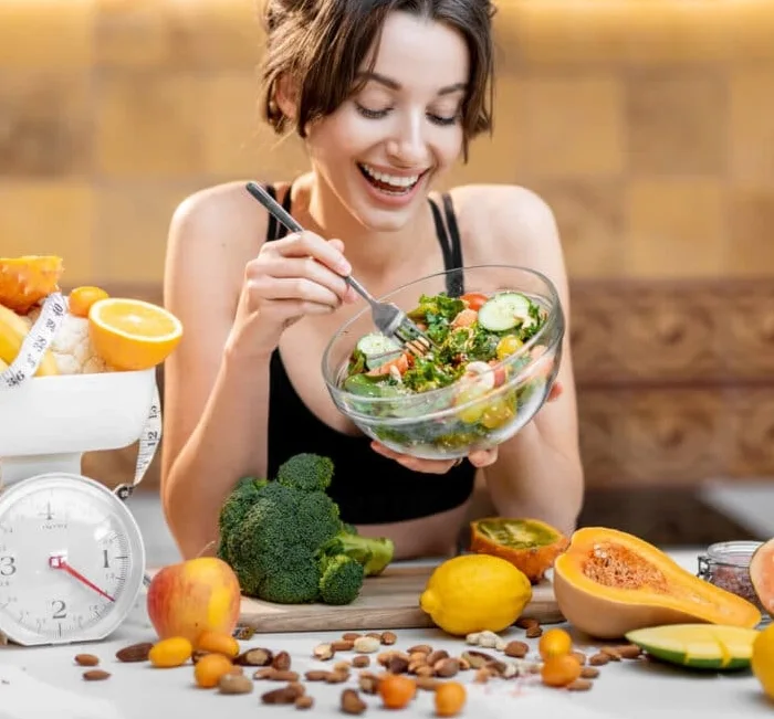 A kitchen scale, fresh vegetables and a bowl of salad, illustrating planning a routine